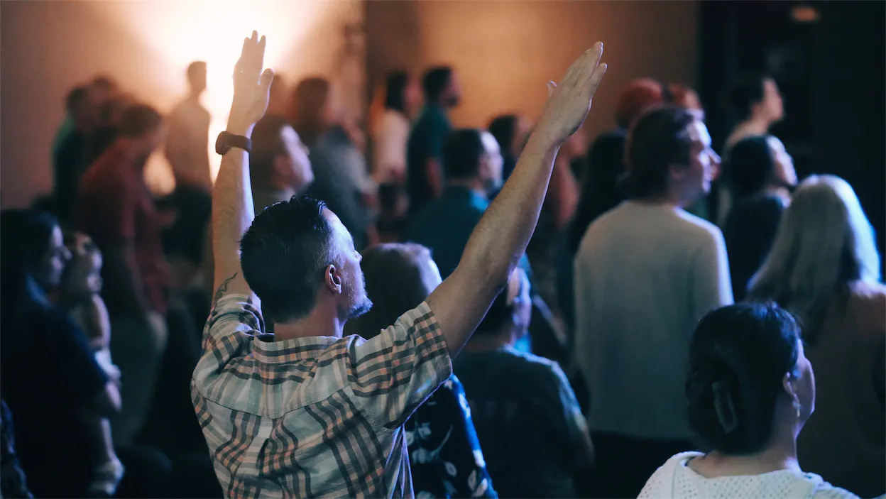 man with arms raised in worship