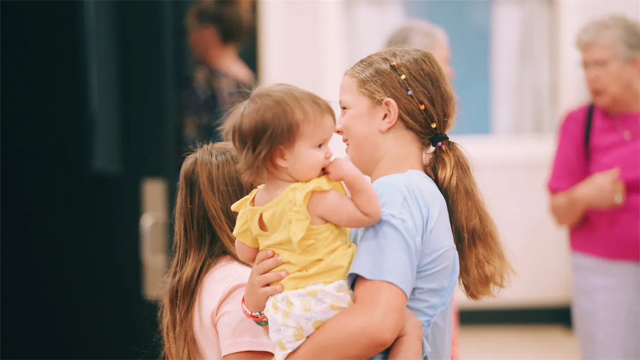 A sister holding her younger sister.