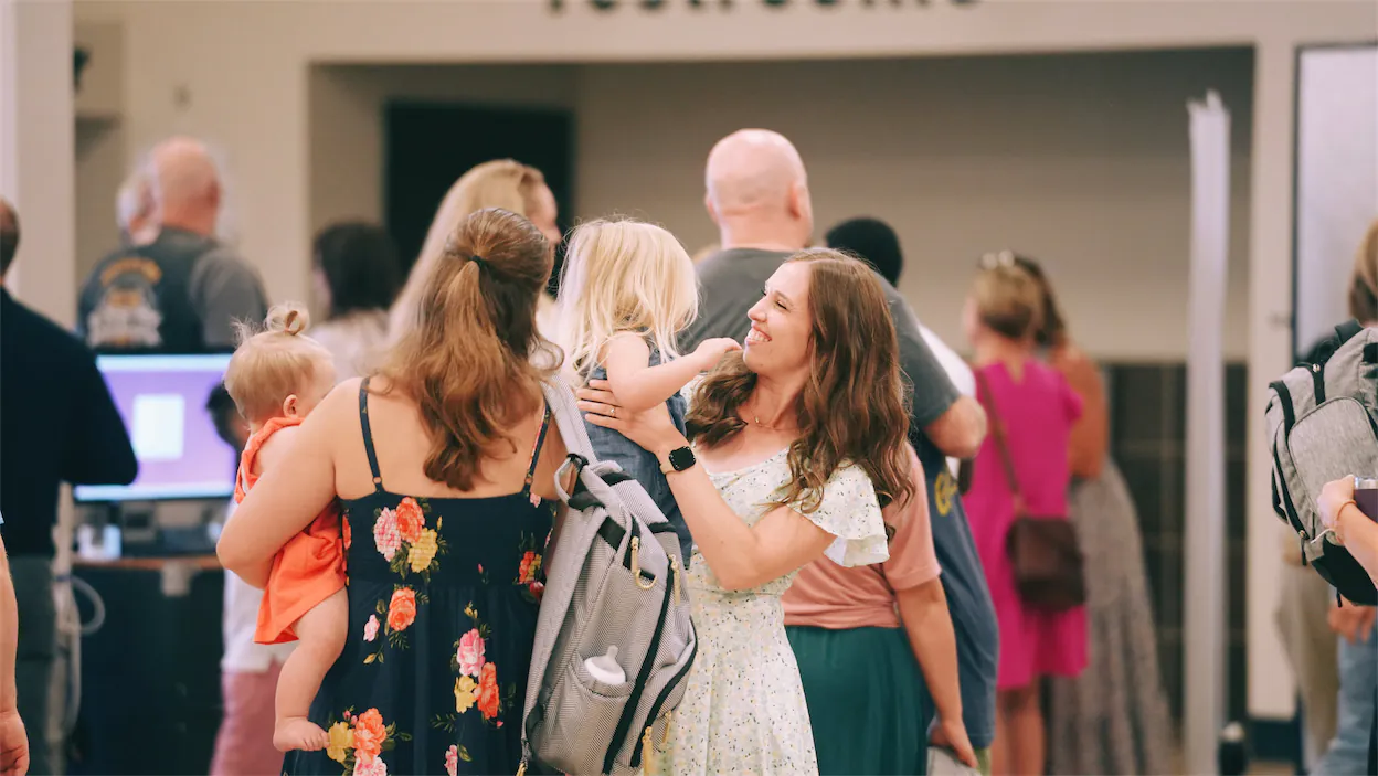 a mom holding a child and smiling